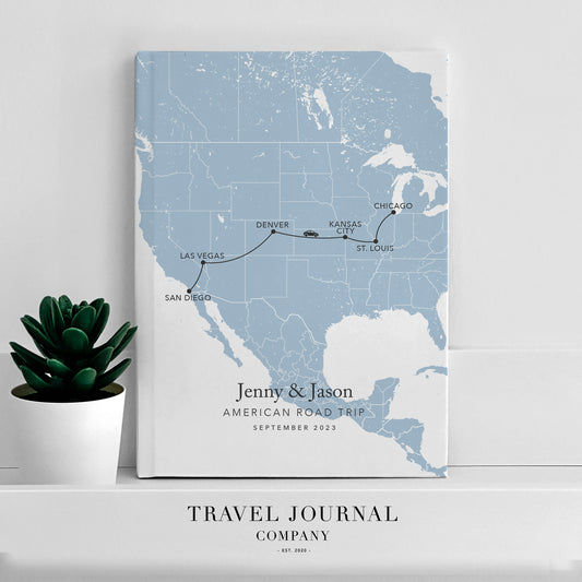 a travel journal sitting on top of a shelf next to a potted plant
